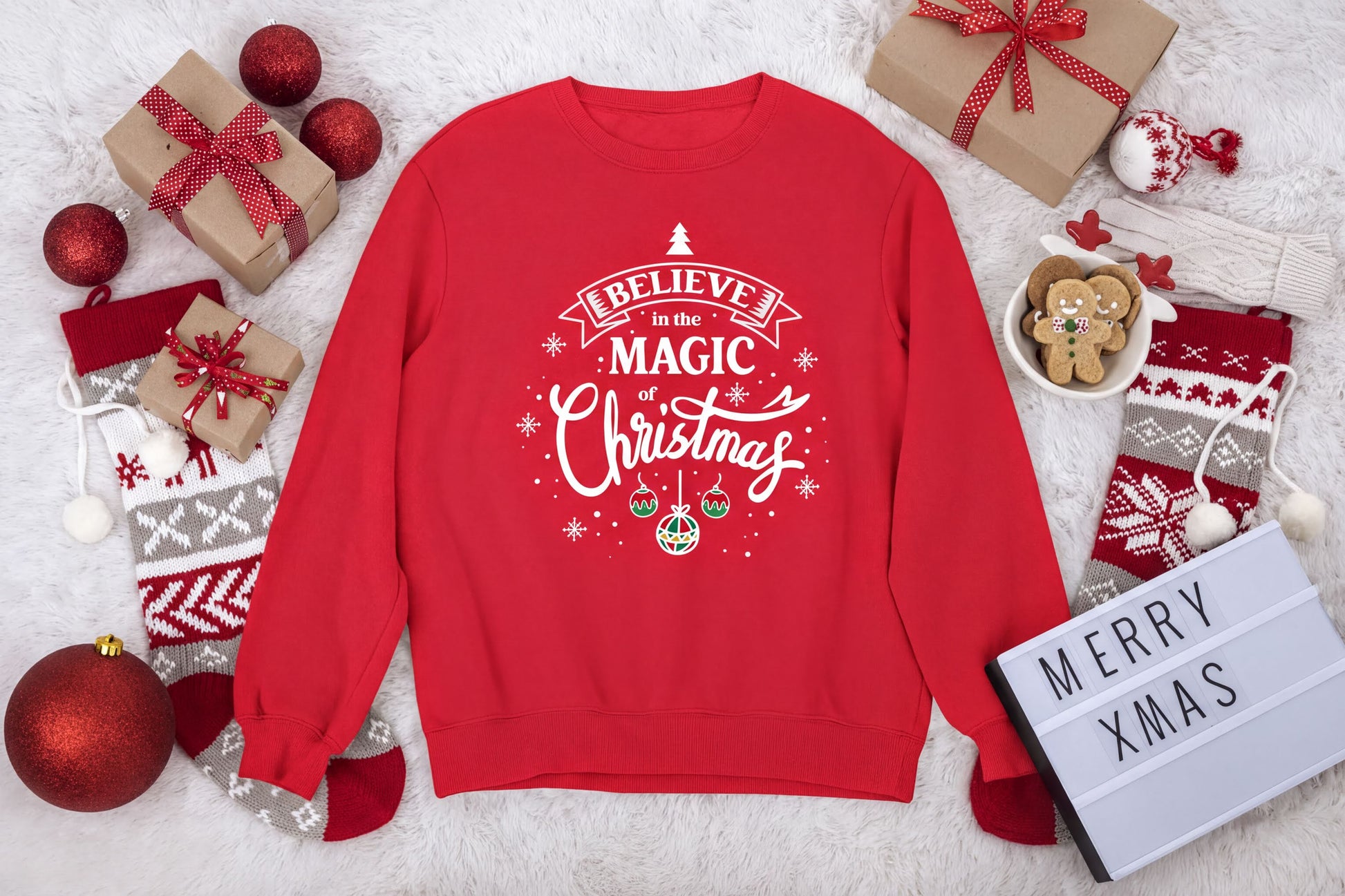A red sweater with a Christmas-themed design, surrounded by various holiday decorations and gifts, including a sign that says "Merry Xmas".