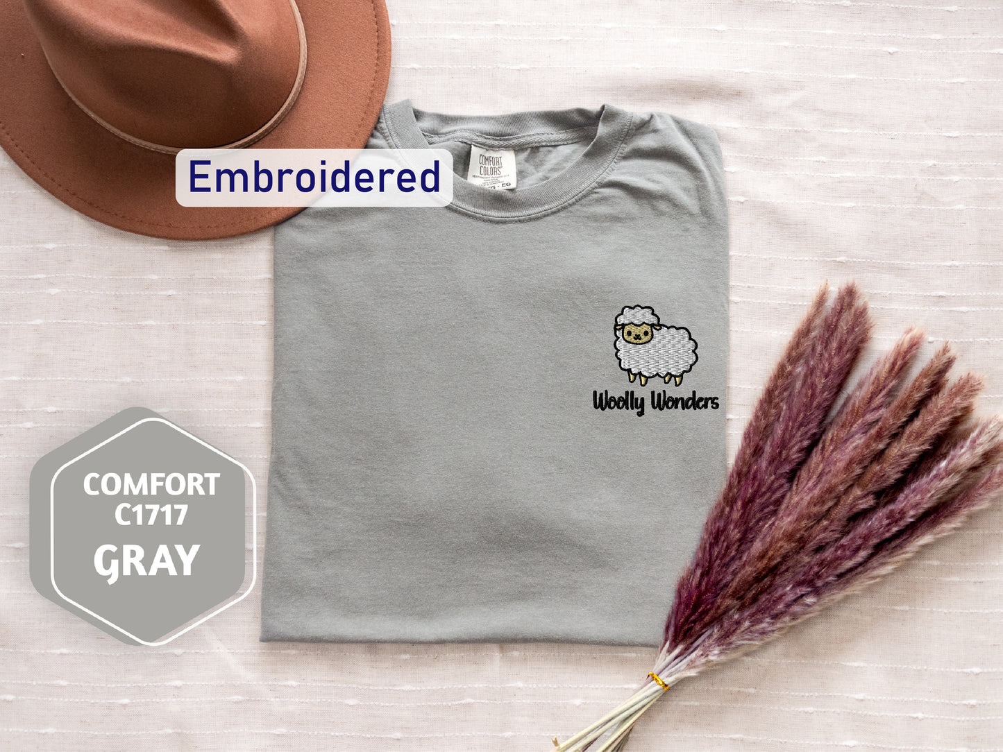 a hat, a t - shirt, and some dried grass are on a bed