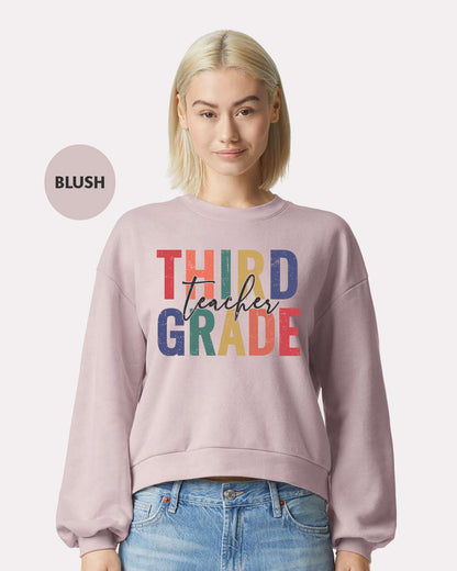 a woman wearing a sweatshirt that says third grade