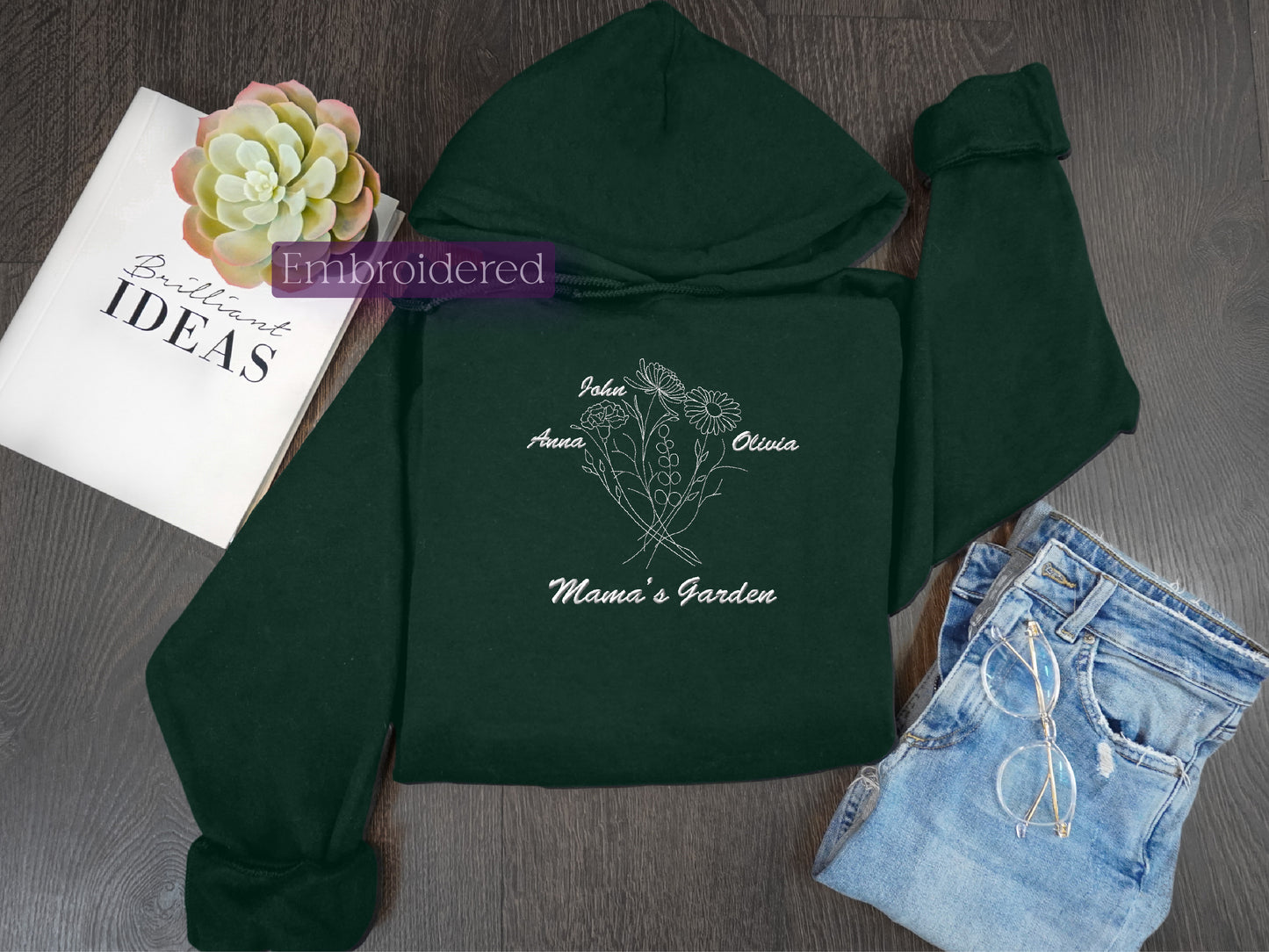 a green hoodie with a flower and a book