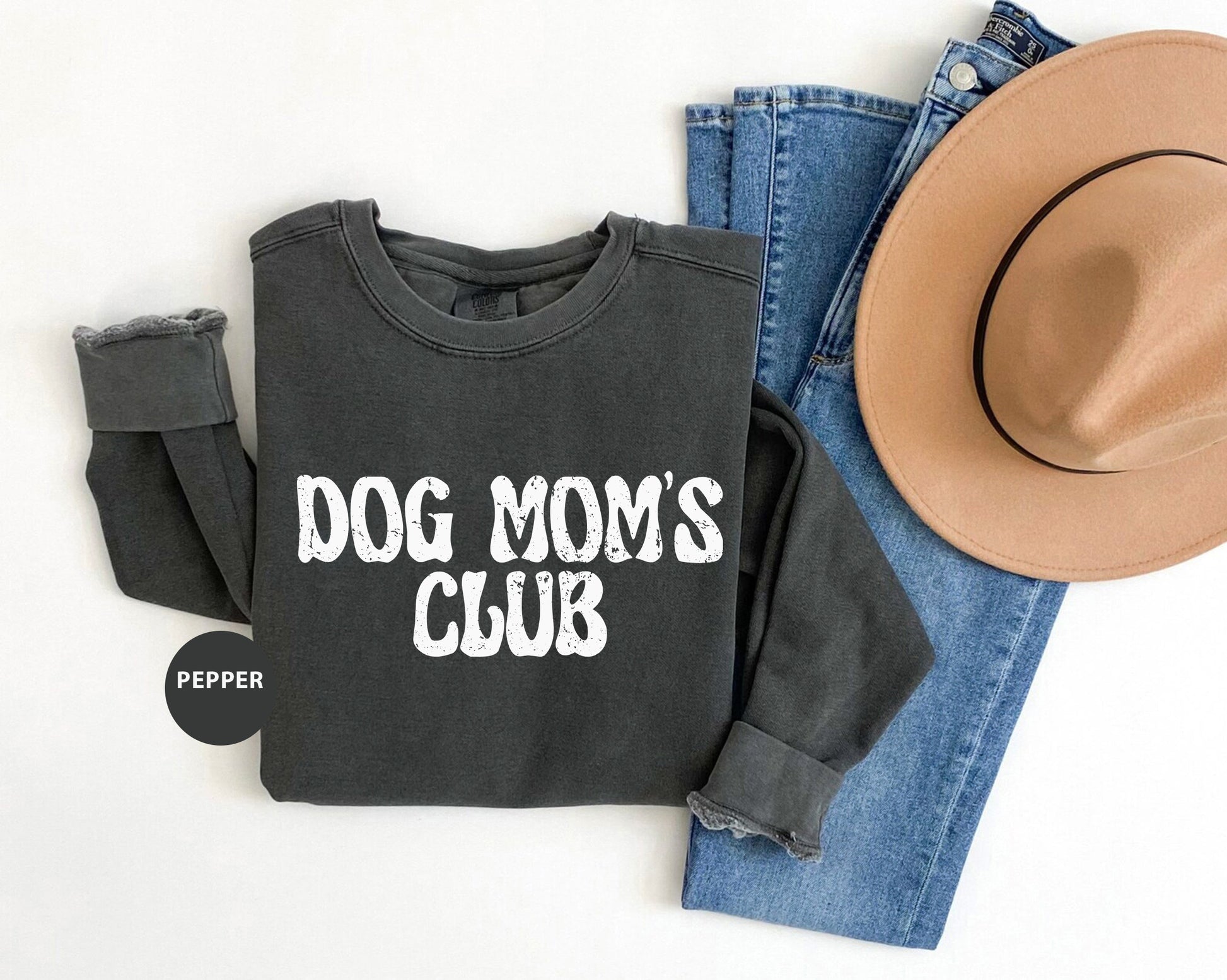 a dog mom's club sweatshirt, jeans and a hat