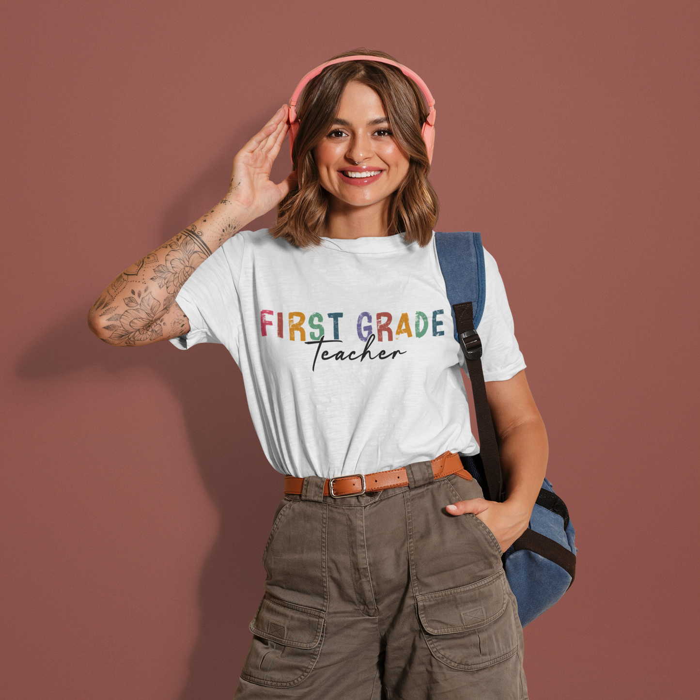 a woman wearing a white t - shirt with the words first grade teacher on it