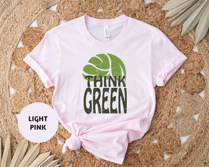 a pink shirt with a green leaf on it