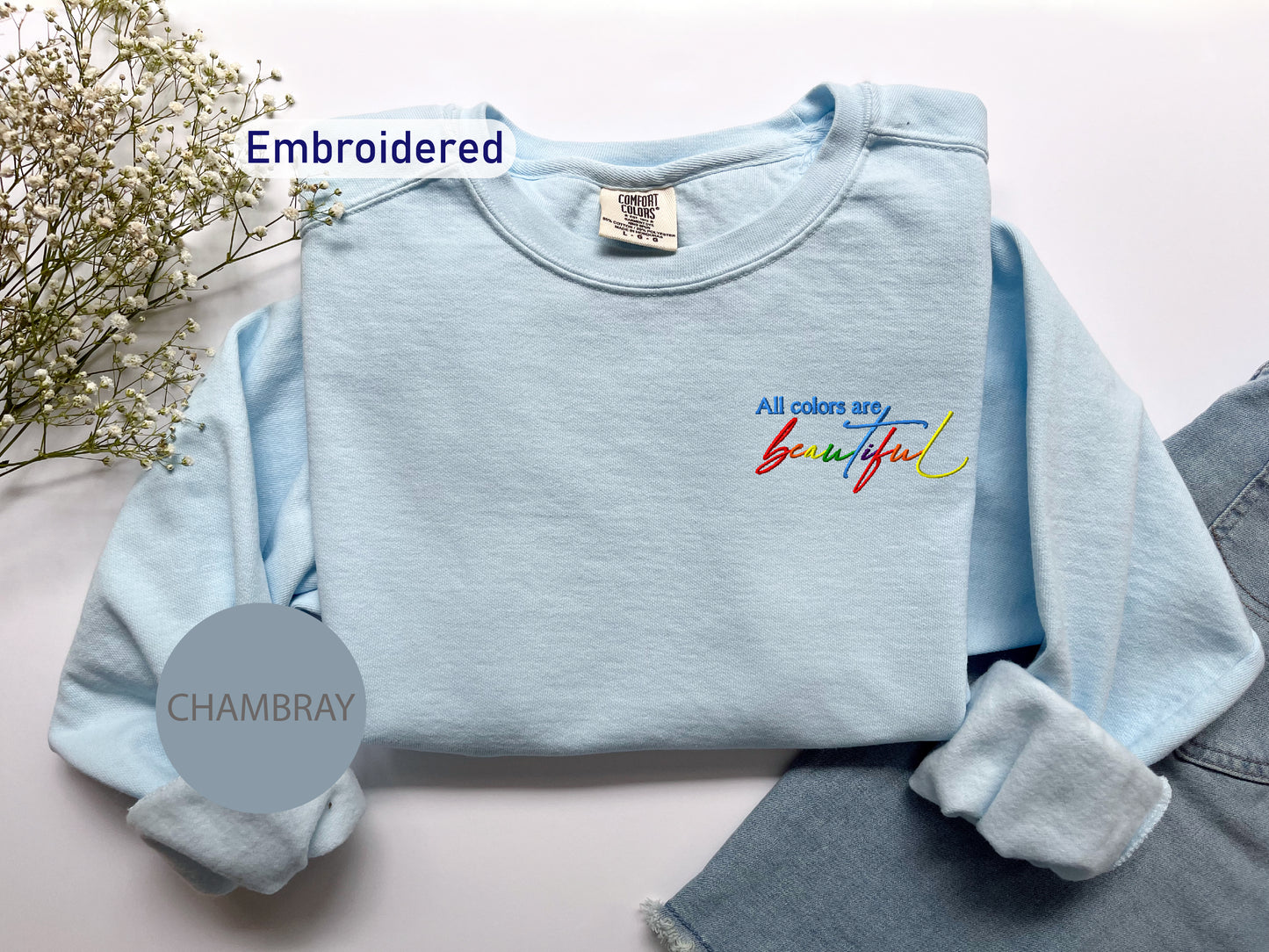 a blue sweater with embroidered words on it