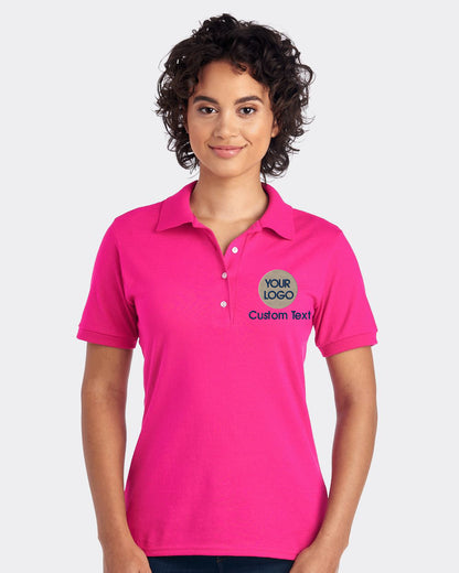 a woman wearing a pink polo shirt with a green logo