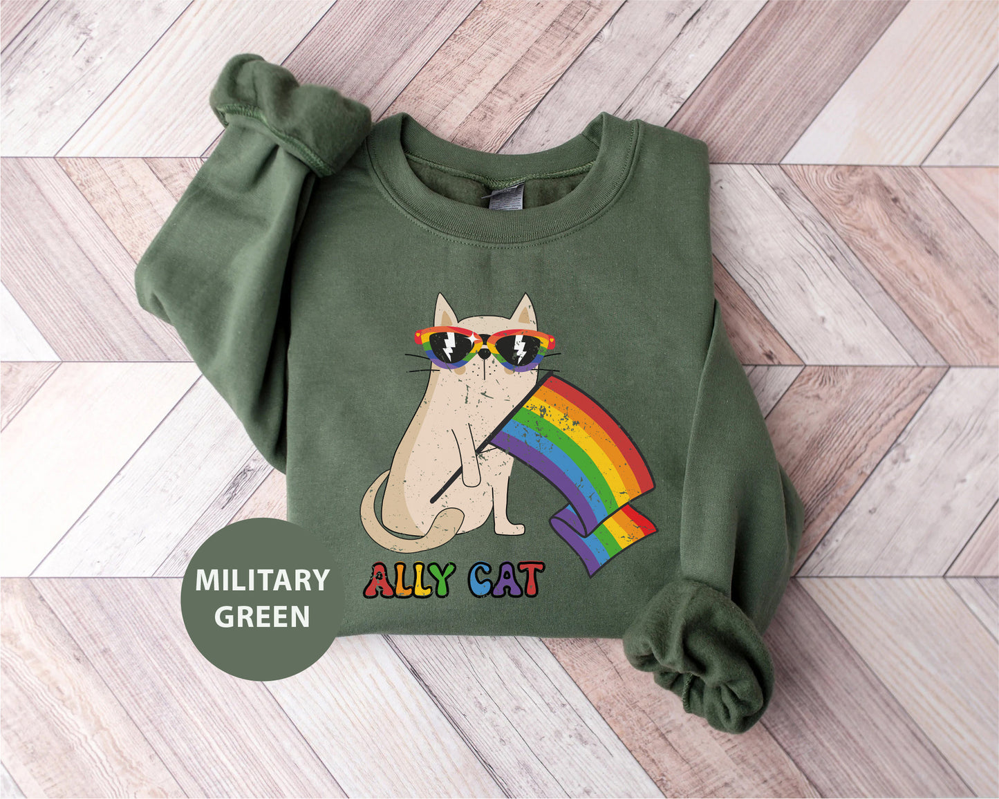 a green sweatshirt with a cat wearing sunglasses and a rainbow on it