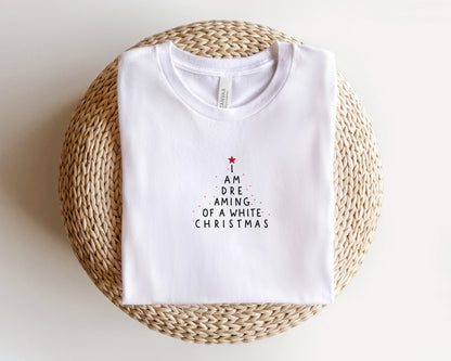 A white t-shirt with a Christmas-themed design printed on it, placed on a woven basket.