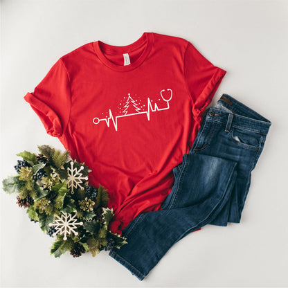 a red t-shirt with a white line drawing of a stethoscope and a tree, along with a pair of blue jeans and a wreath of pine cones.