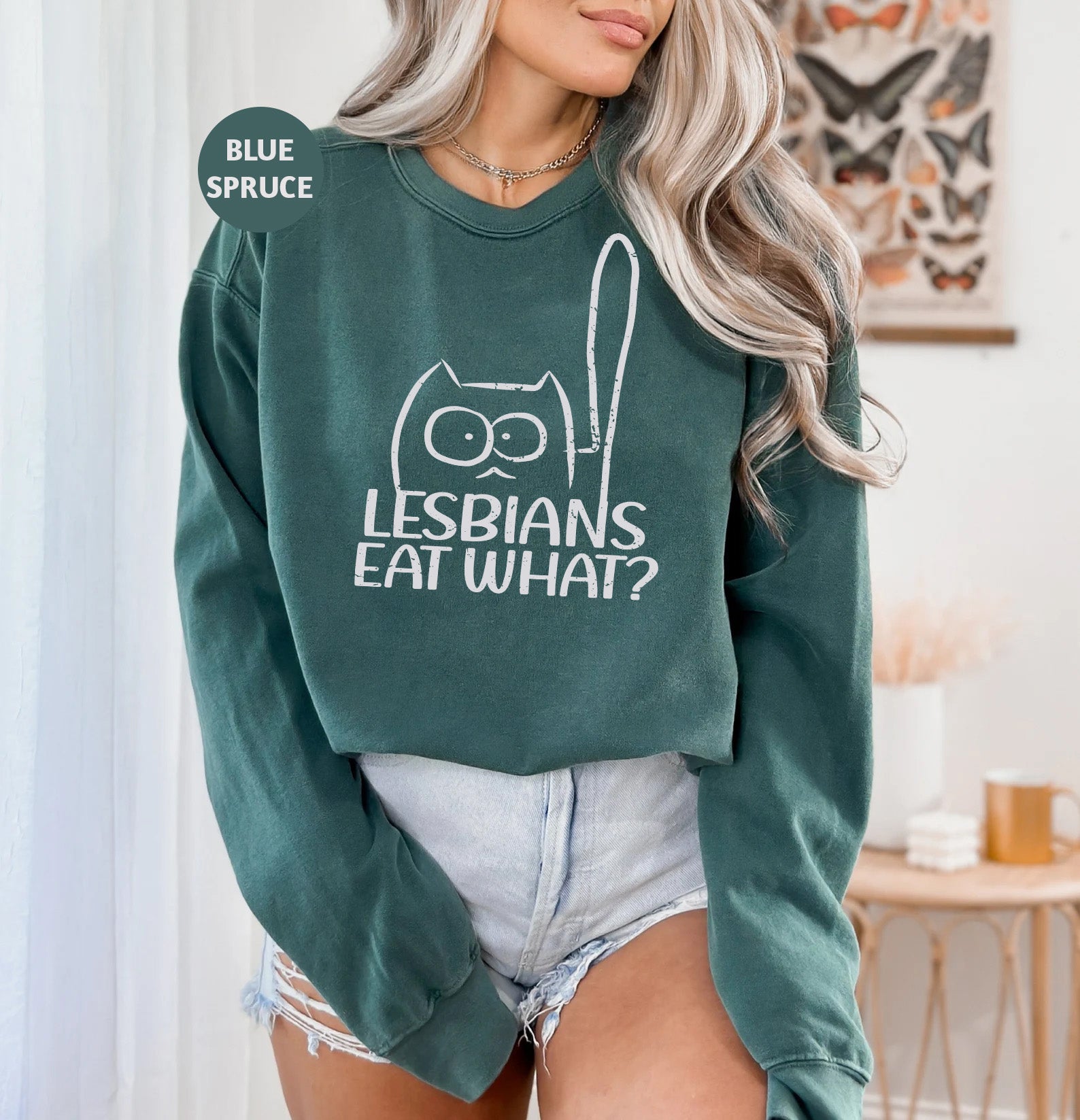 a woman wearing a green sweatshirt that says lesbians eat what?