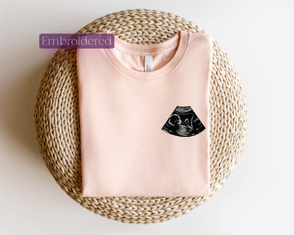 a pink t - shirt with a black cat on it