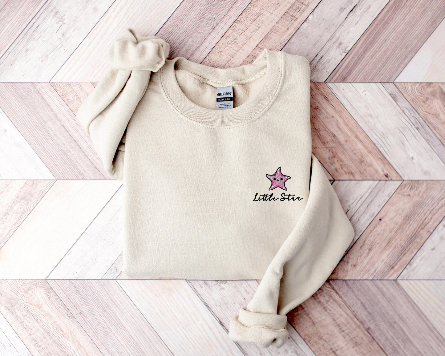 a white sweater with a pink star on it