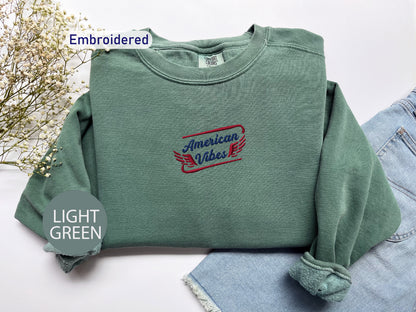 a green sweatshirt with a red and blue embroidered design on it, along with a pair of denim jeans and a light green circular object labeled "LIGHT GREEN".