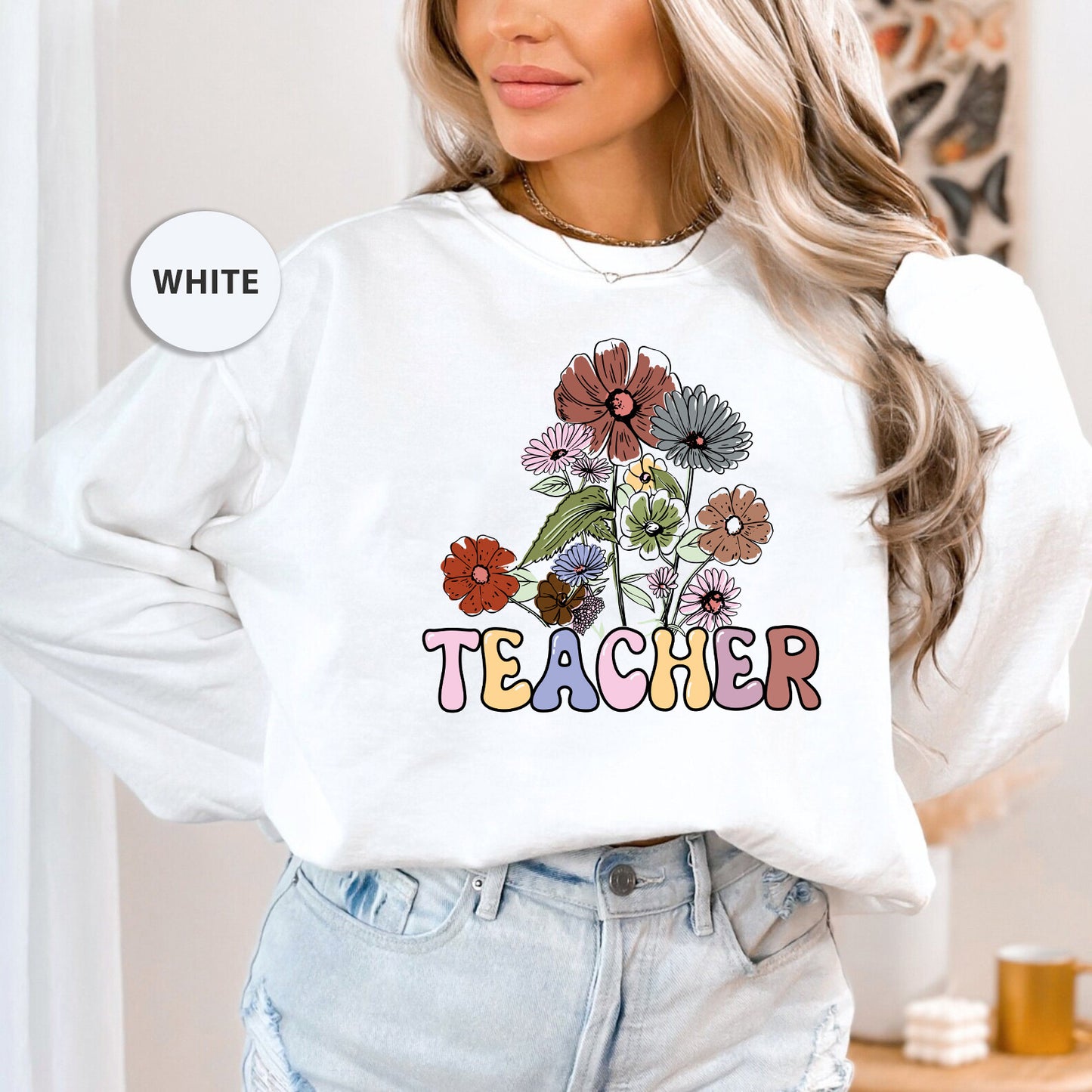 a woman wearing a white sweatshirt with flowers on it