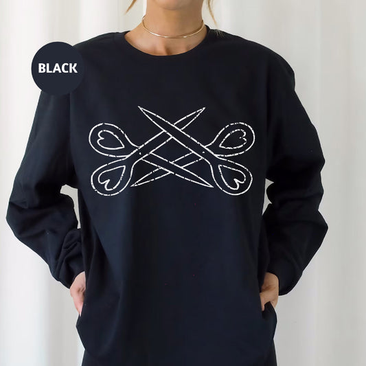 a woman wearing a black sweatshirt with a pair of scissors on it