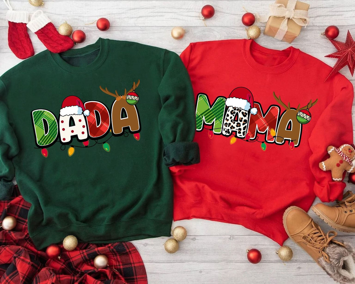 two Christmas-themed sweatshirts with the word "Dada" printed on them, surrounded by various holiday decorations such as ornaments, stockings, and a gift box.