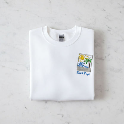 A white t-shirt with a beach-themed design and the text "Beach Days" printed on it.