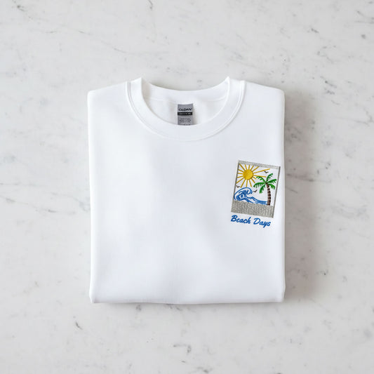 A white t-shirt with a beach-themed design and the text "Beach Days" printed on it.
