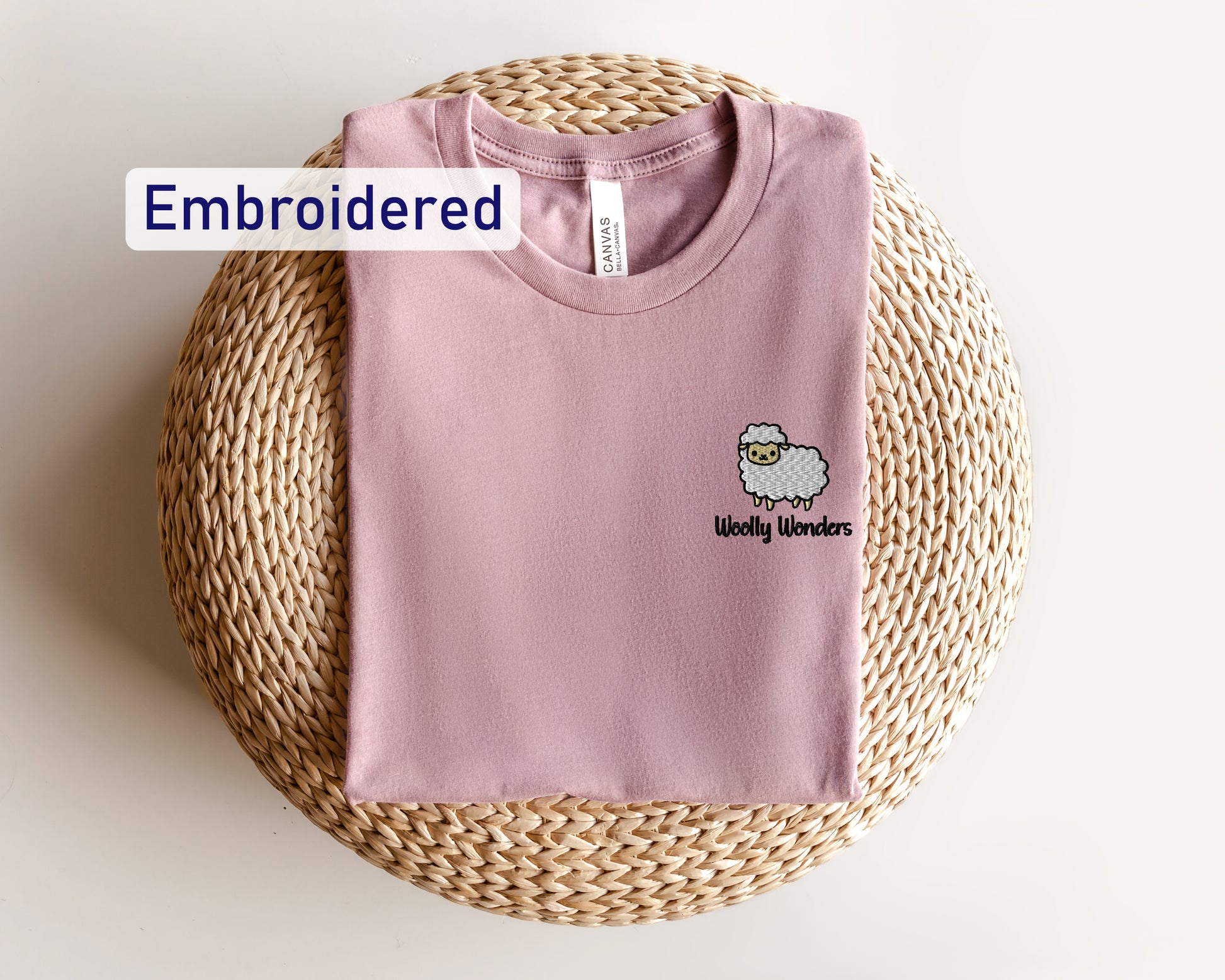 a pink shirt with a sheep embroidered on it