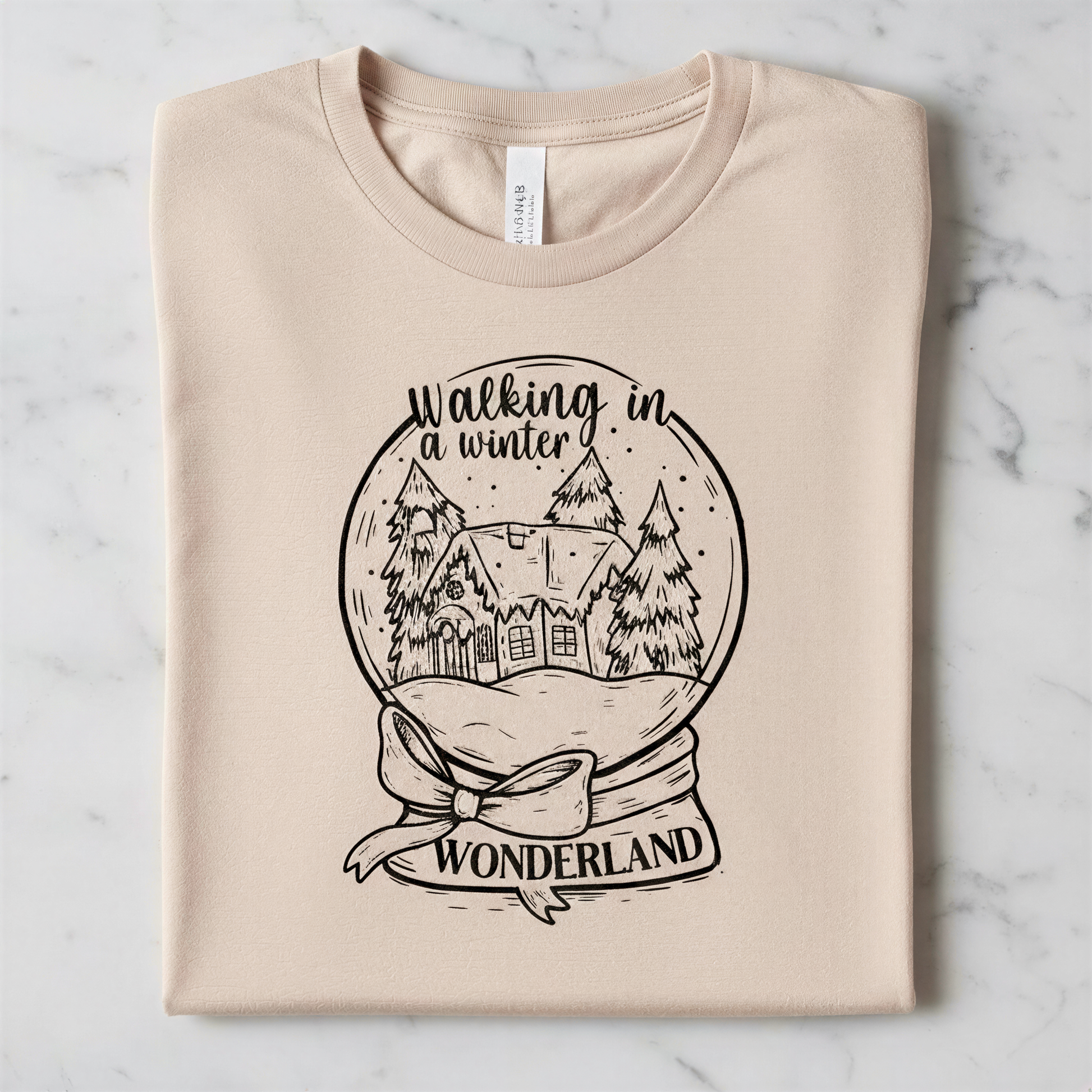 A t-shirt with a graphic design depicting a snow globe containing a winter scene with a house and trees, along with the text "Walking in winter wonderland".