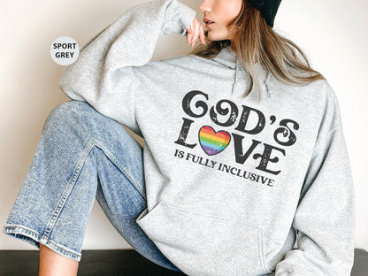 a woman sitting on the ground wearing a sweatshirt with the words god's love