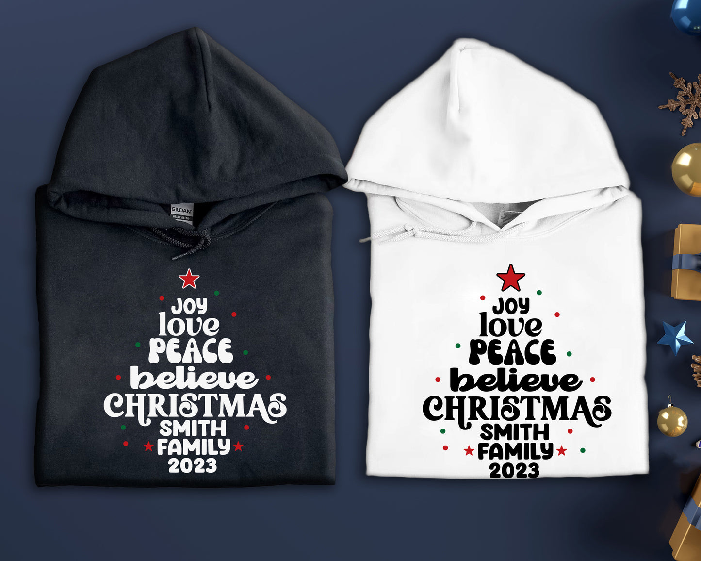 two hooded sweatshirts with Christmas-themed text printed on them, placed on a blue background.