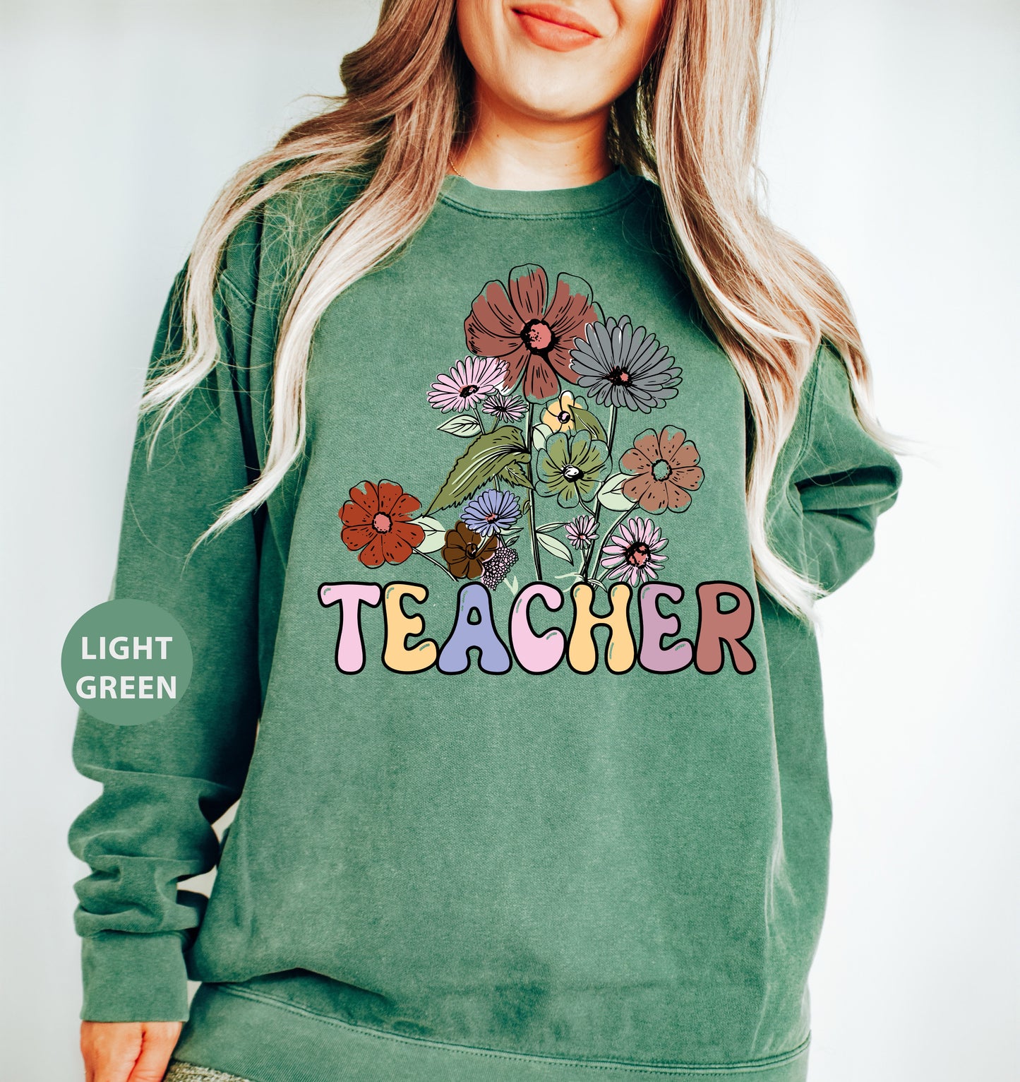 a woman wearing a green sweatshirt with flowers on it