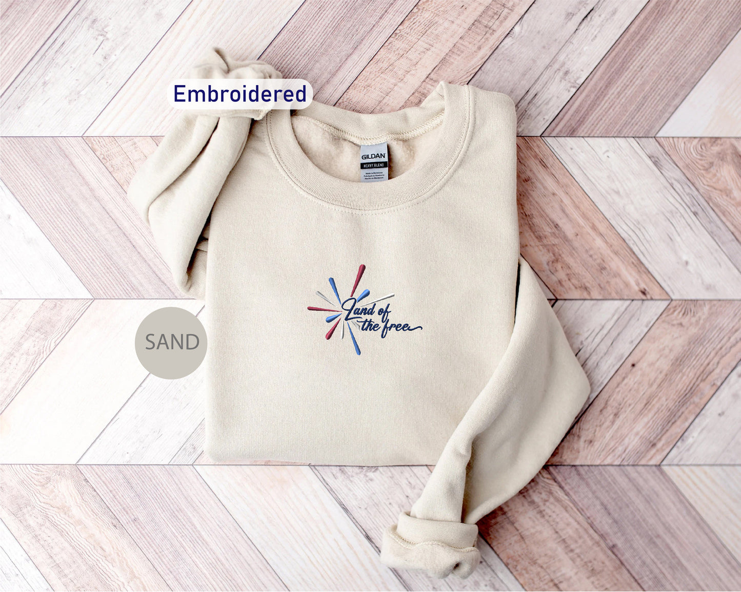 a beige sweater with a graphic design on it, placed on a wooden surface.