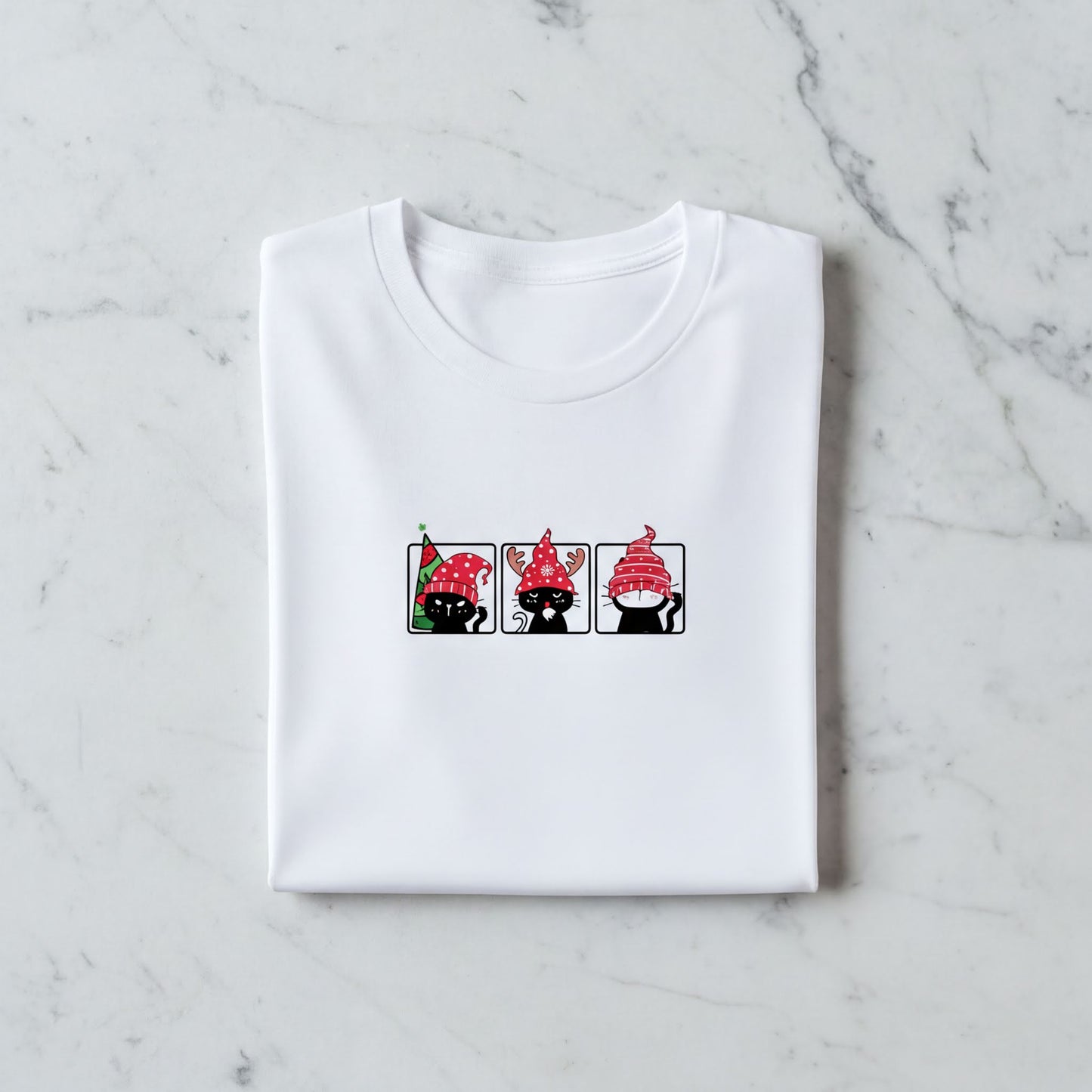 A white t-shirt with a graphic design featuring three cartoon cats wearing red hats.