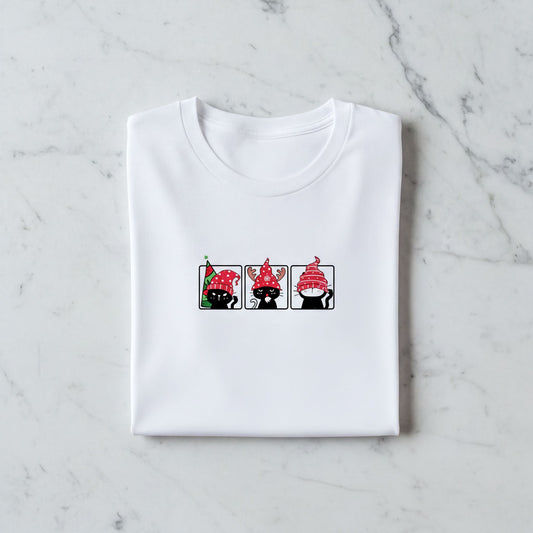 A white t-shirt with a graphic design featuring three cartoon cats wearing red hats.