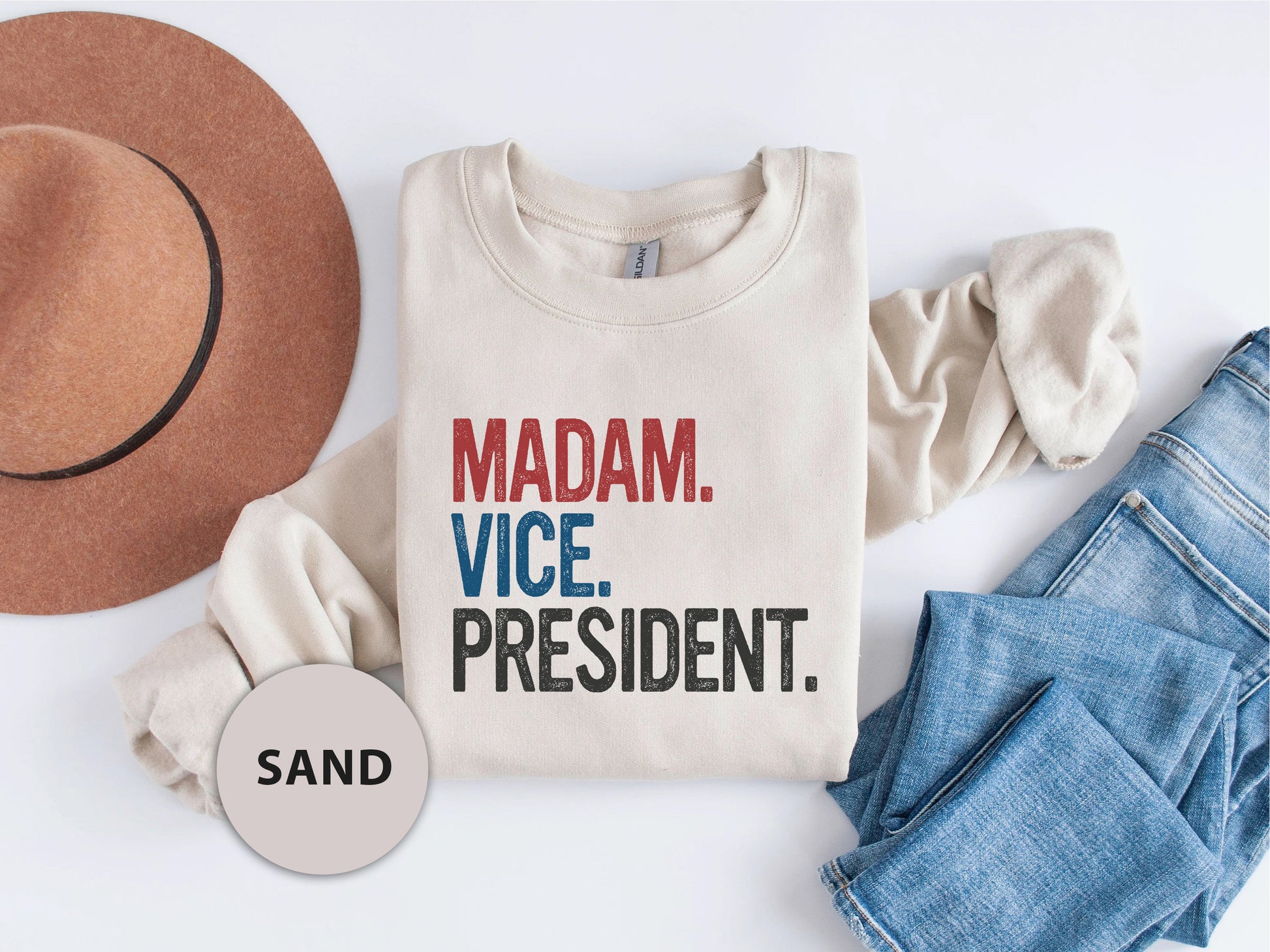 a t - shirt that says madam vice president next to a hat and jeans