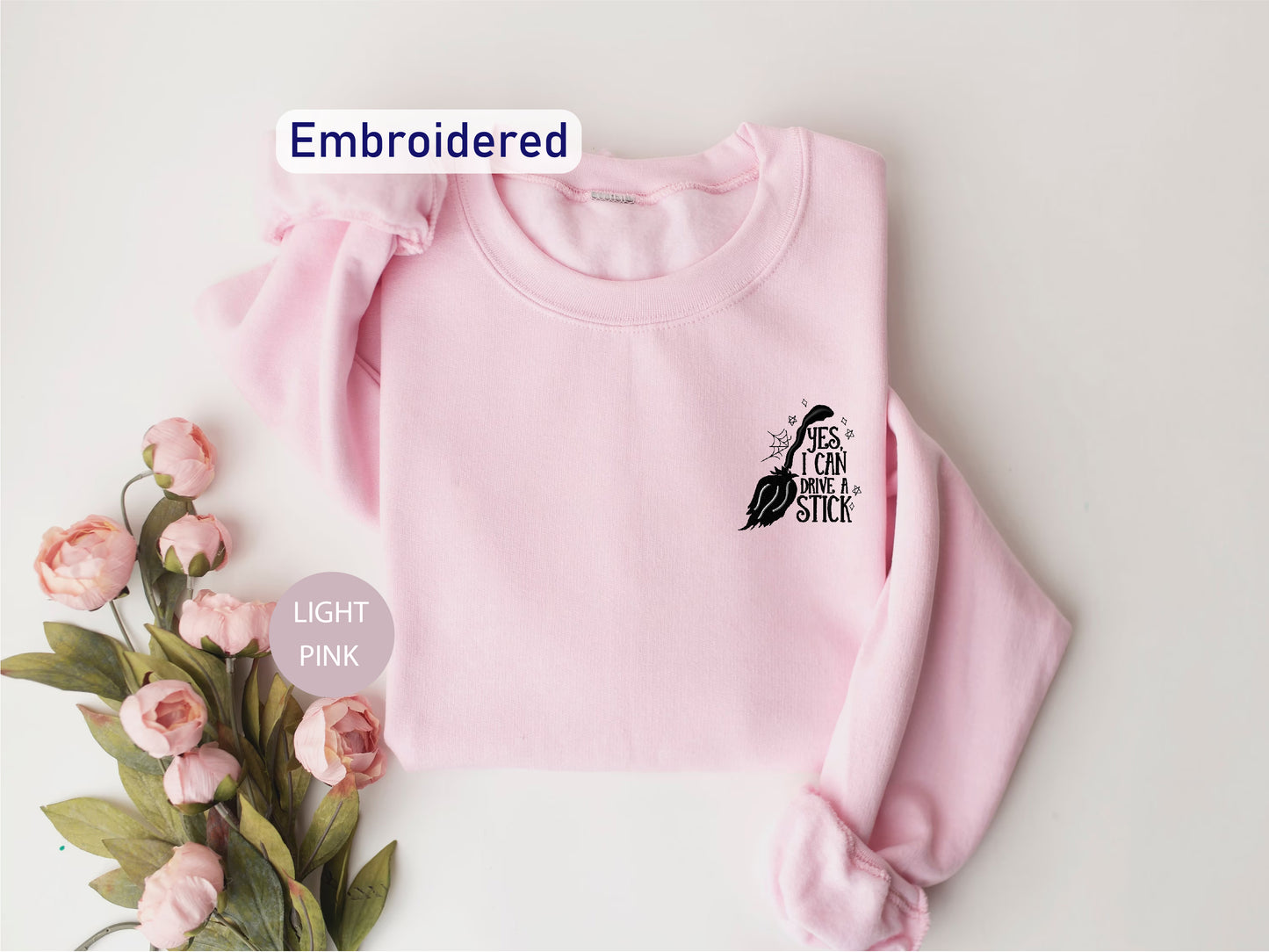 a pink sweater with a bird embroidered on it