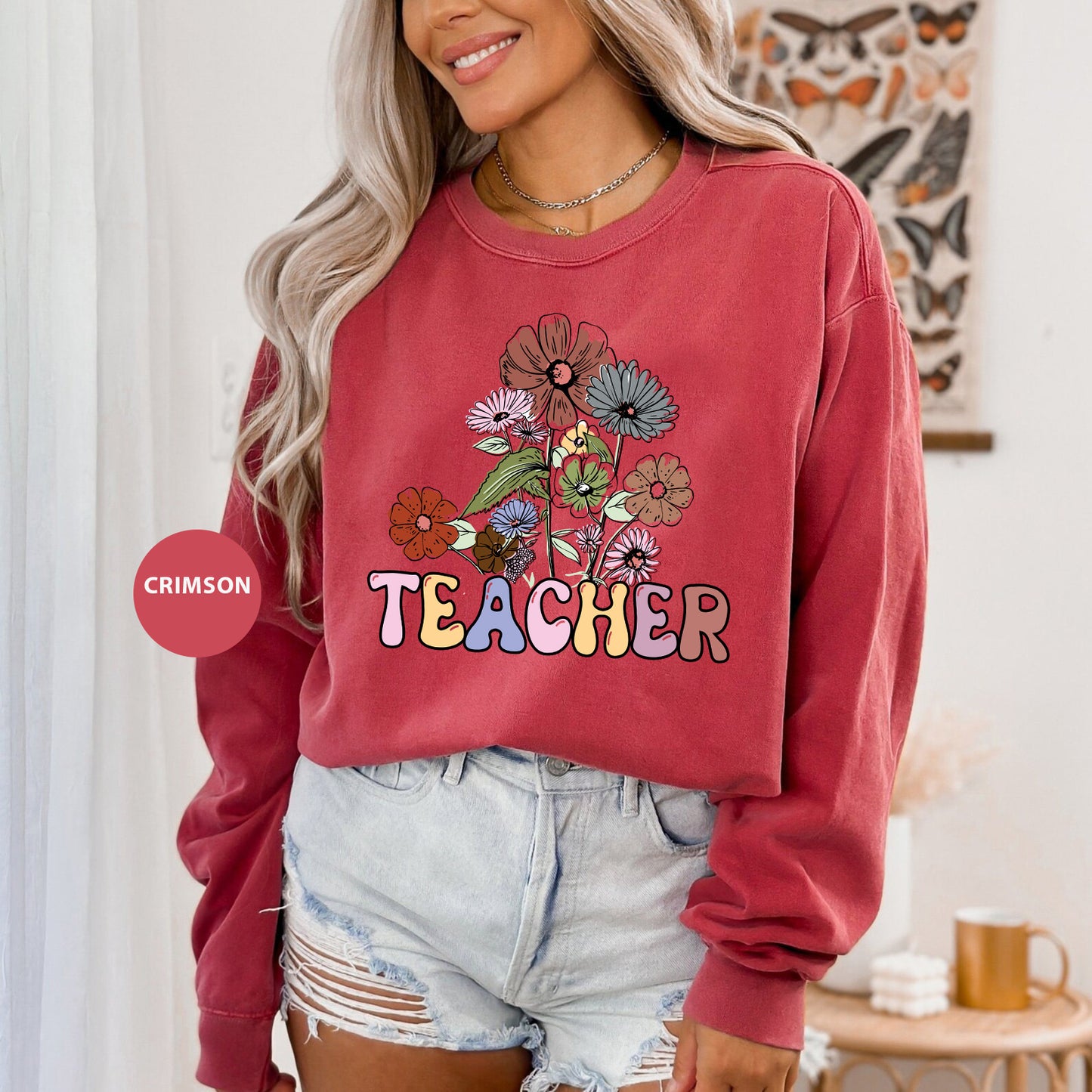 a woman wearing a red sweatshirt that says teacher