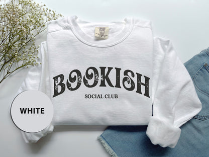 a t - shirt that says bookish social club next to a pair of jeans