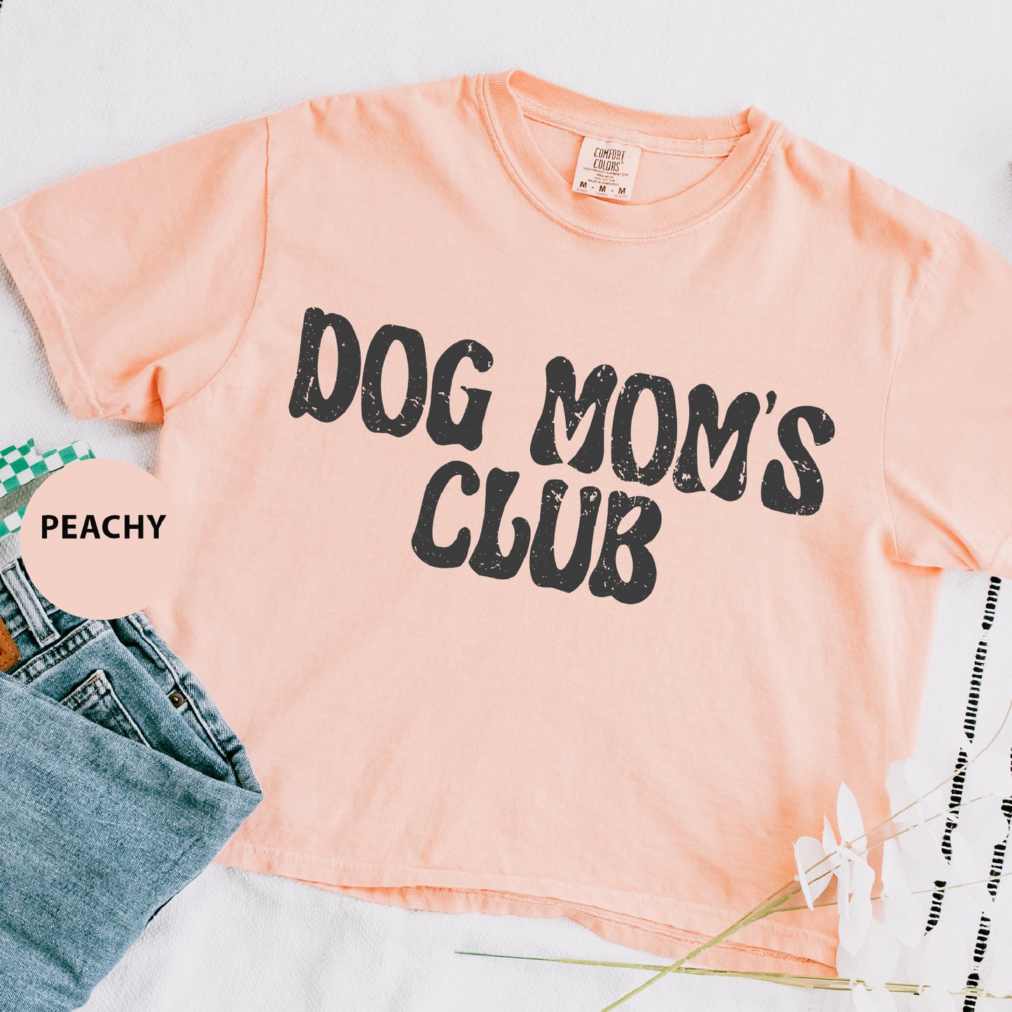 a shirt that says dog mom's club next to a pair of jeans