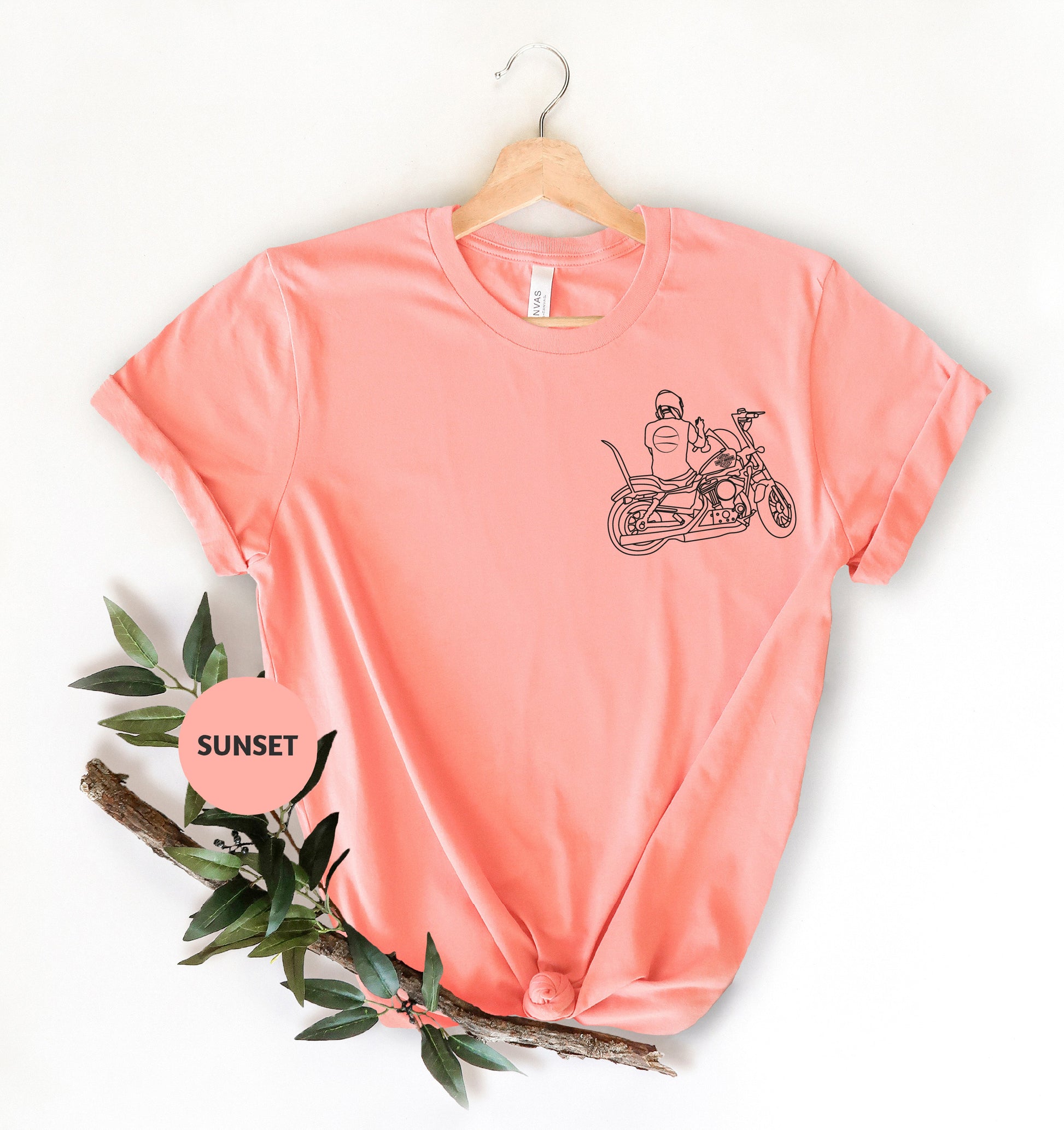 a pink shirt with a picture of a man riding a motorcycle