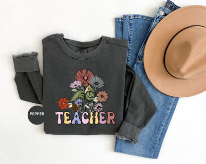 a hat, jeans, and a t - shirt with the words teacher on it