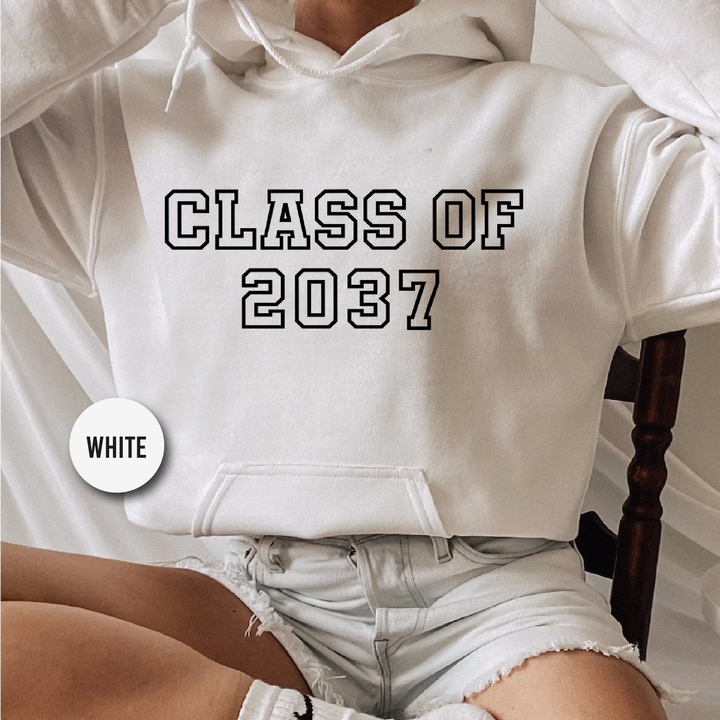 a woman wearing a white hoodie that says class of 2077