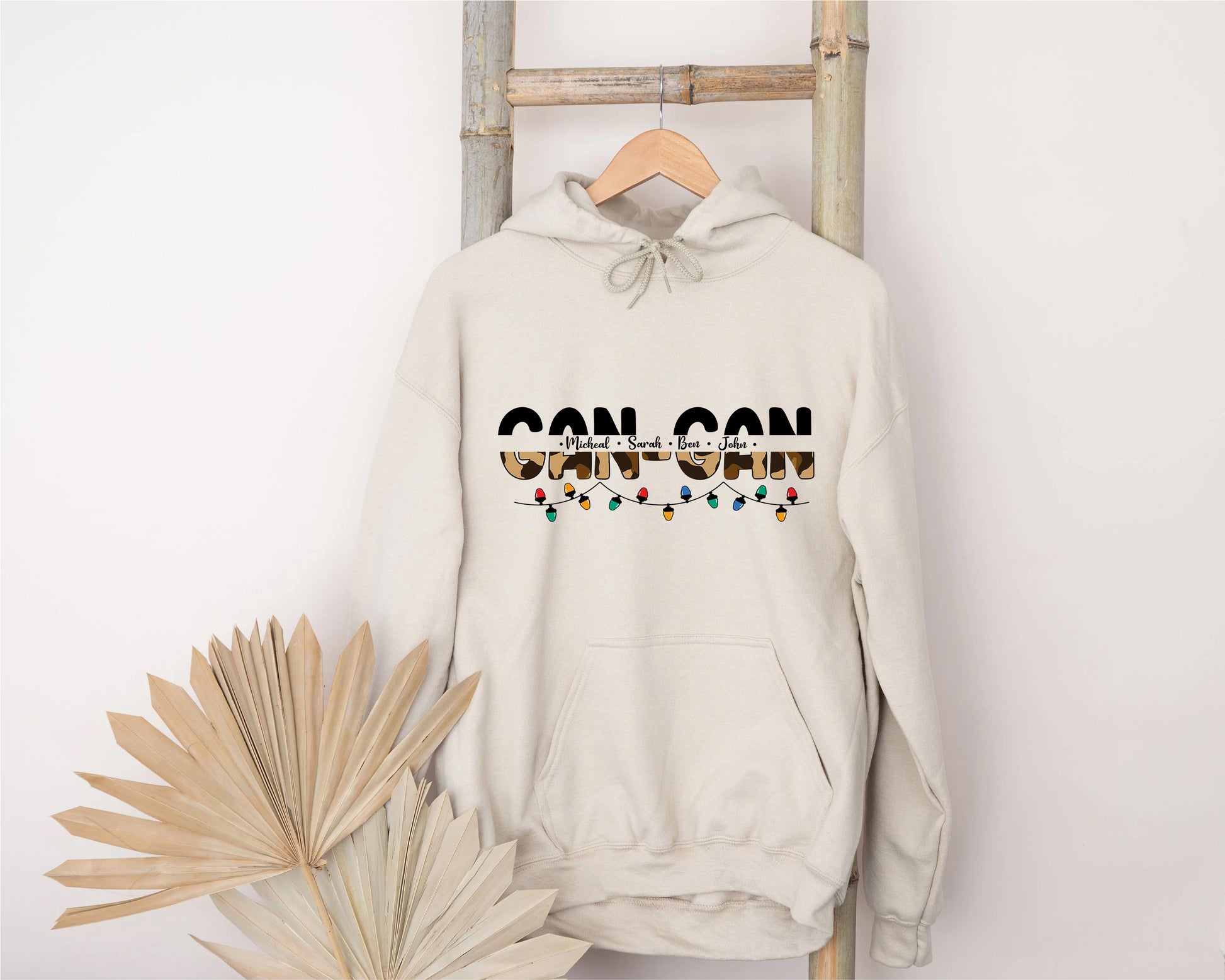 A white hoodie with the word "GONGO" printed on it, hanging on a wooden hanger.