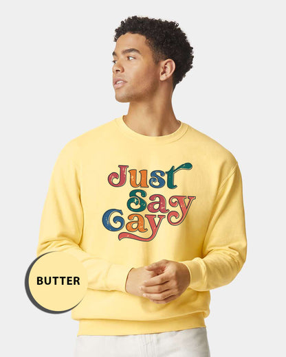 a man wearing a yellow sweatshirt with the words just gay on it