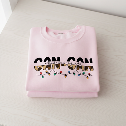 A pink sweatshirt with the text "CAN-CAN" printed on it, along with a graphic of colorful Christmas lights.