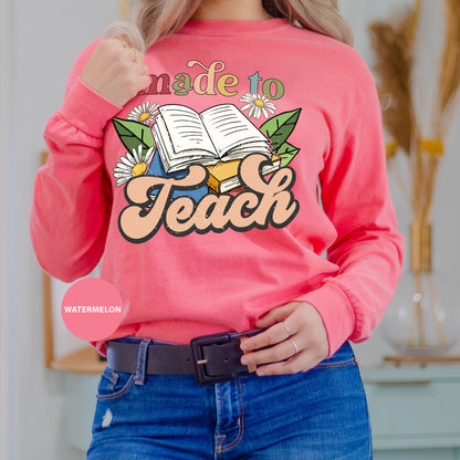 a woman wearing a pink sweatshirt that says made to teach