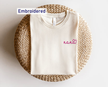 a white t - shirt with a pink embroidered name on it