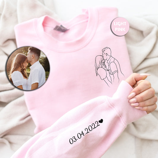 a person holding a pink shirt with a picture of a man and woman on it