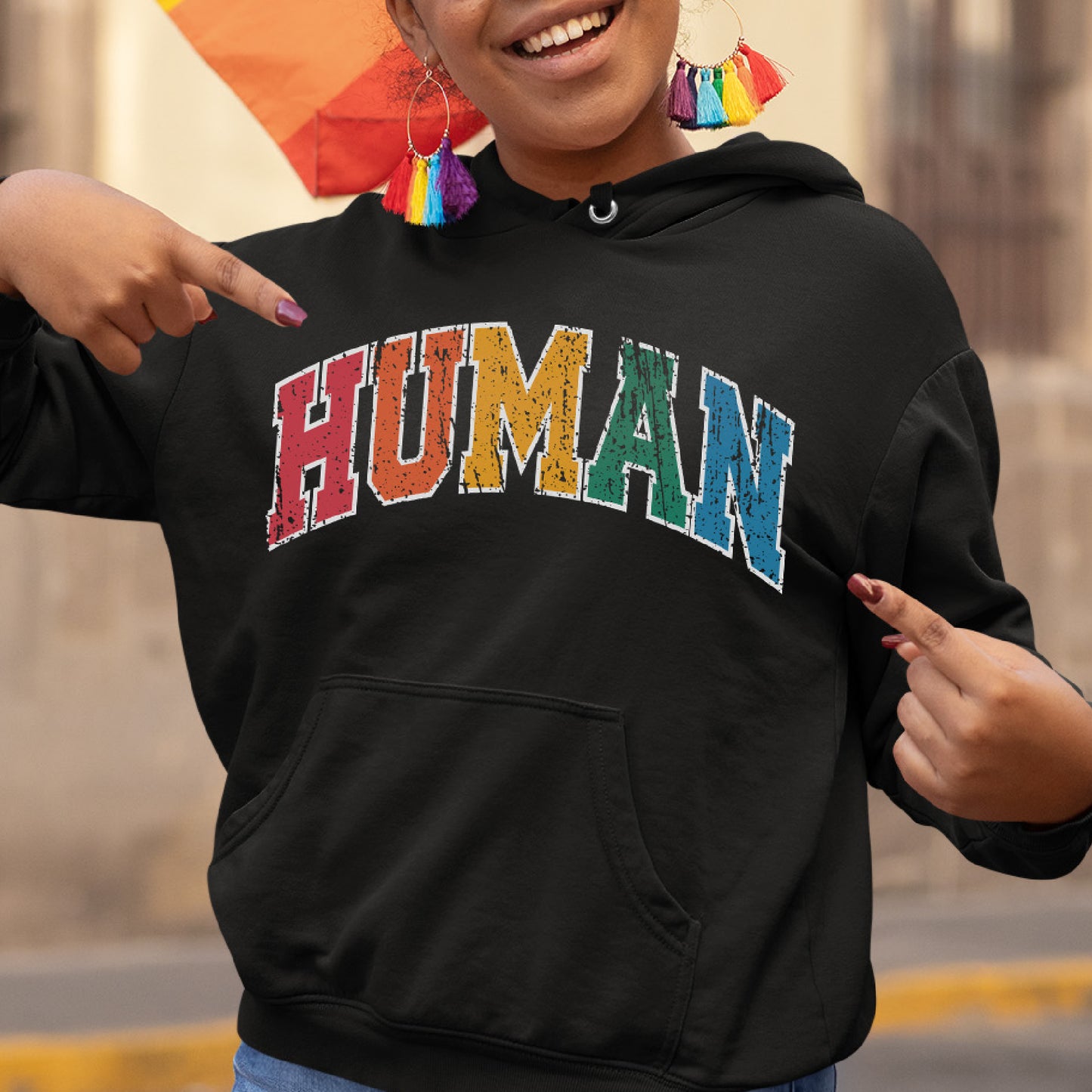 a woman wearing a black hoodie with the word human painted on it