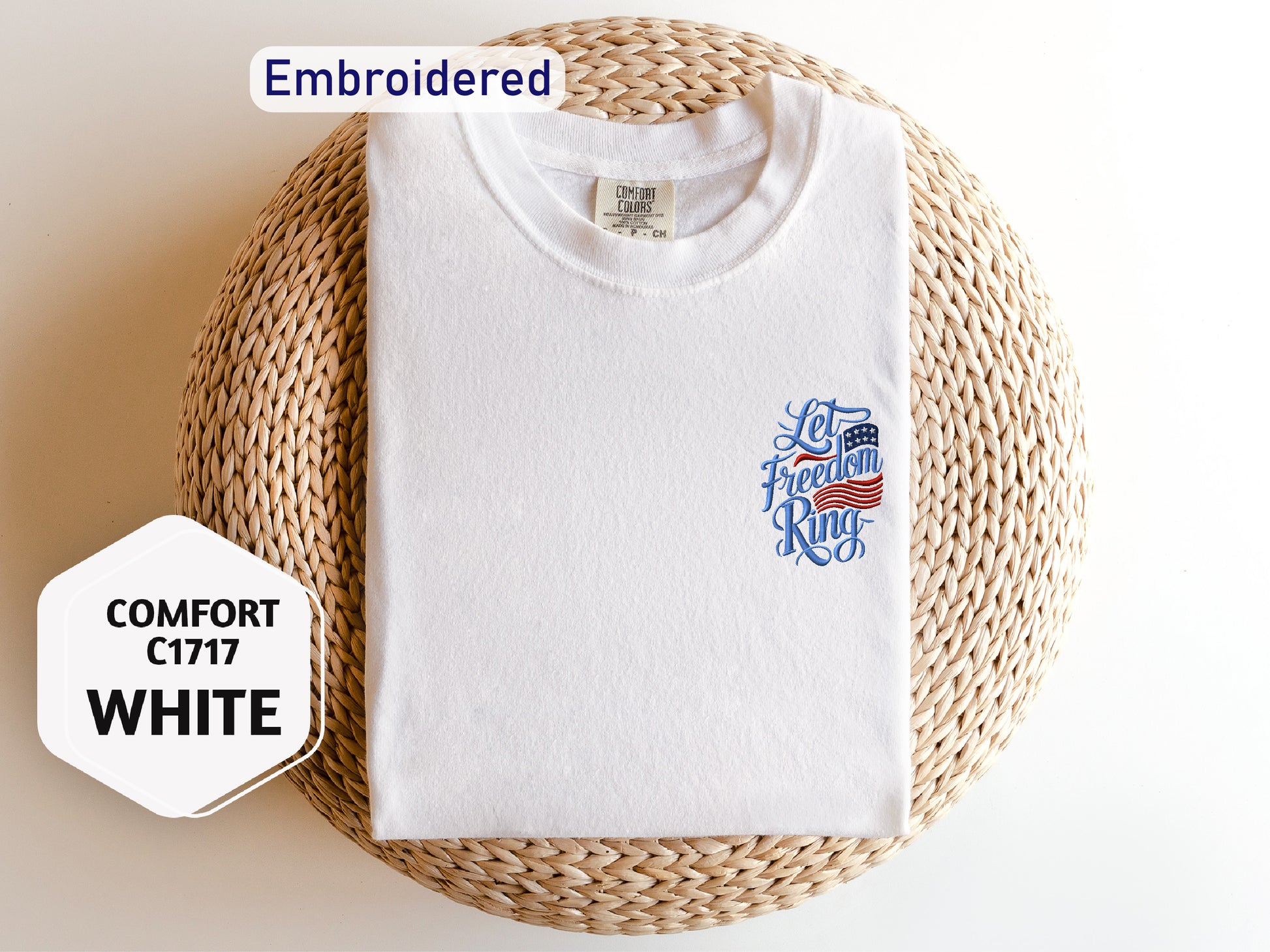 A white t-shirt with a patriotic design, including an American flag and the text "Let's fight for freedom" is displayed on a woven basket.
