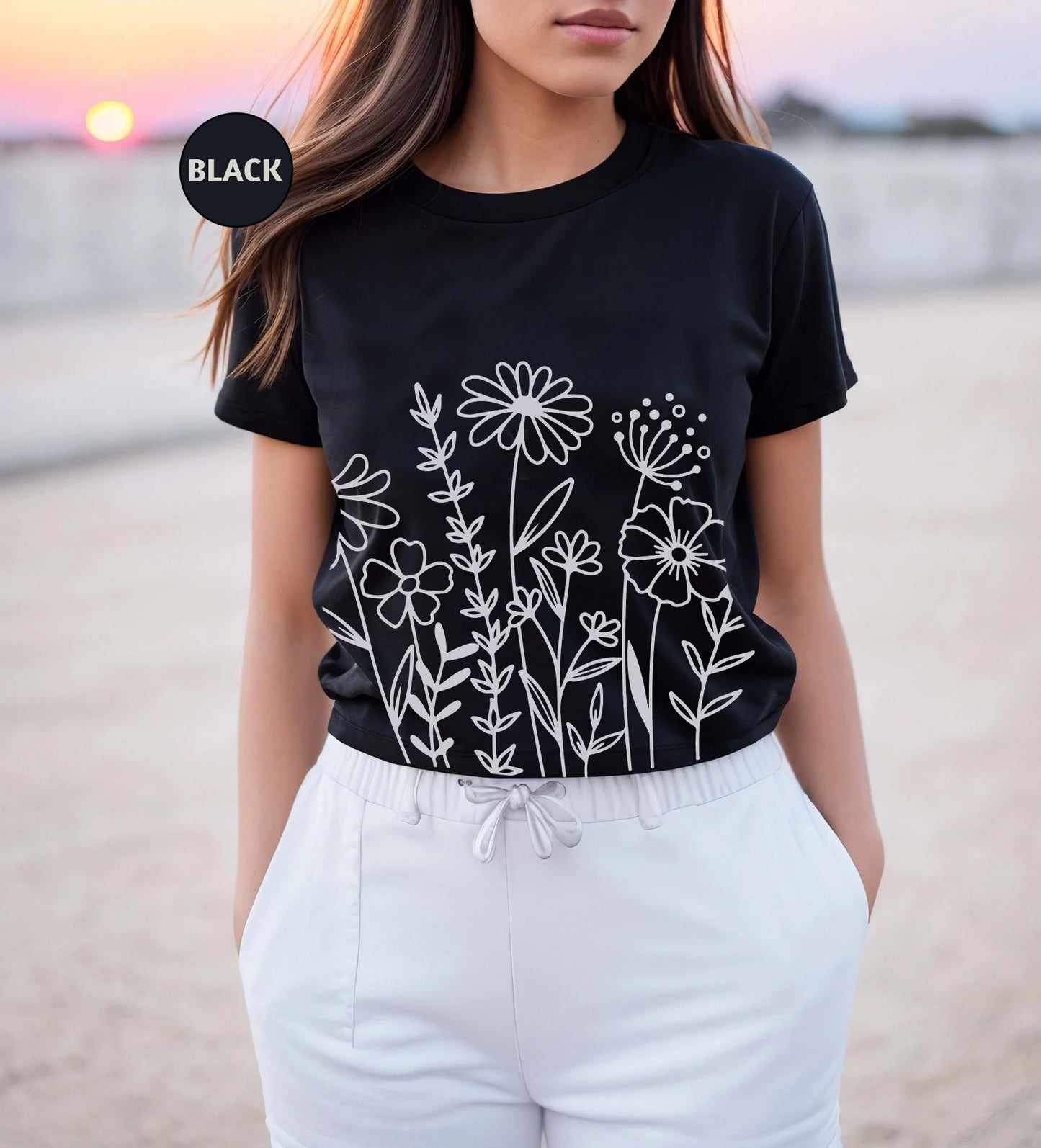 a woman wearing a black t - shirt with flowers on it