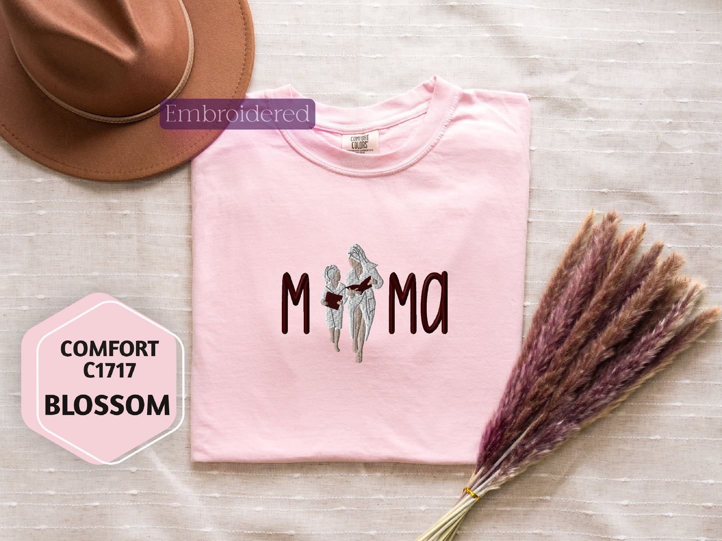 a pink t - shirt with the word mom on it next to a hat and