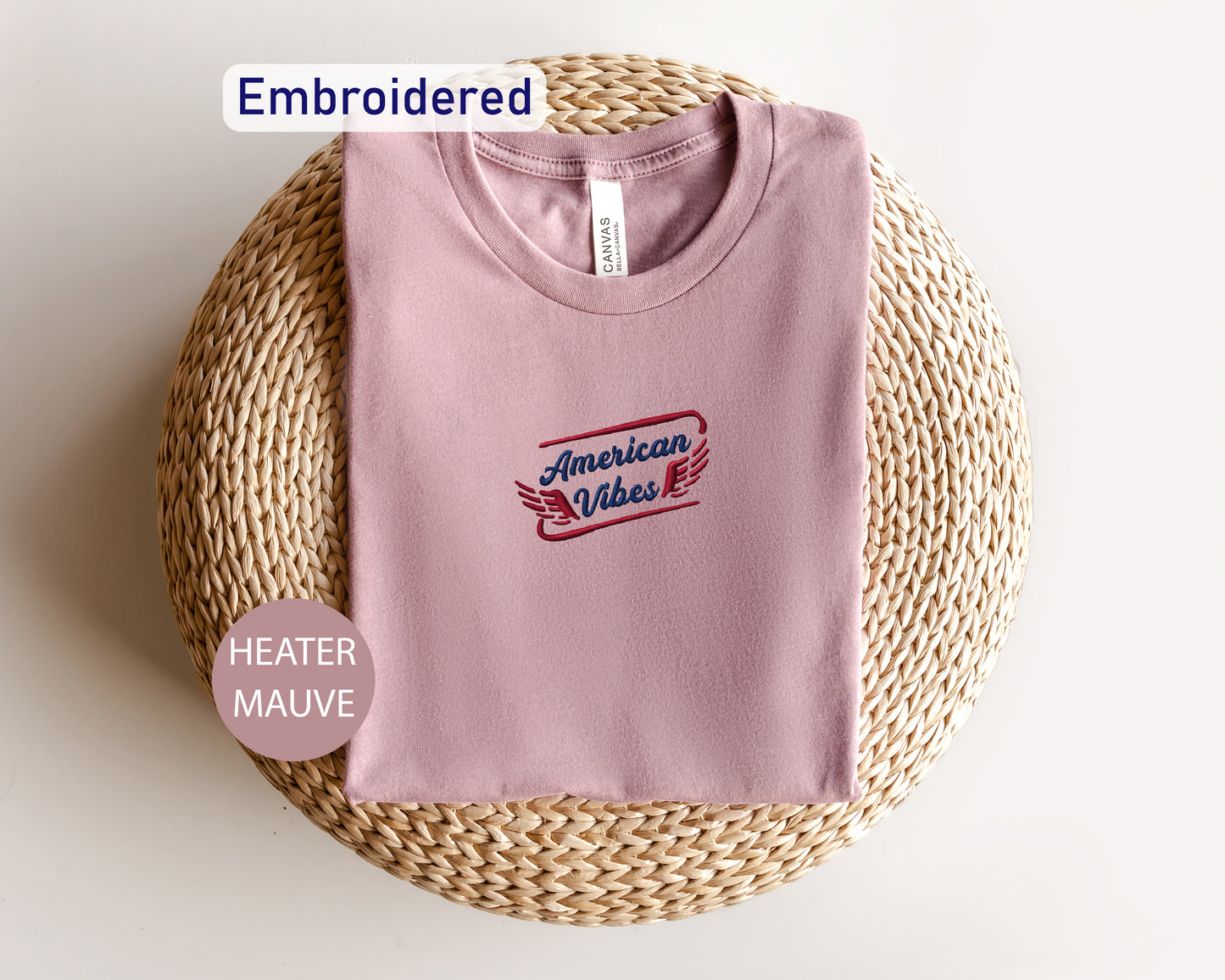 a pink t-shirt with a printed design on it, placed on a woven basket or mat.