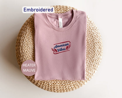 a pink t-shirt with a printed design on it, placed on a woven basket or mat.