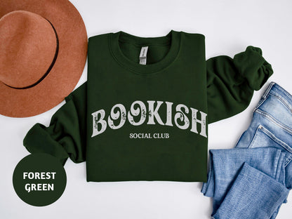 a green shirt that says booksh social club next to jeans and a hat